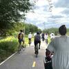 a group of bicyclists riding on a bike path