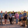 a group of people smiling after cleaning up a desert river